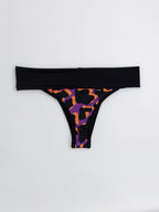 Bikini tanga faja estampado de manchas naranjo y morado, cintura ancha negra, vista frontal — Kinibe