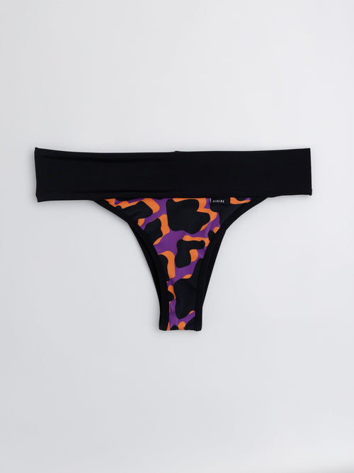 Bikini tanga faja estampado de manchas naranjo y morado, cintura ancha negra, vista frontal — Kinibe